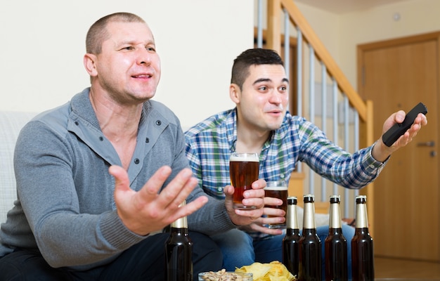 Deux fans de sport masculins regarder le match à la maison