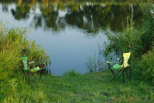 Deux fauteuils verts dans le contexte d'un beau lac Reflet dans l'eau