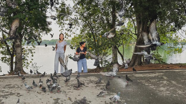 Photo deux femelles nourrissent des oiseaux dans le parc.