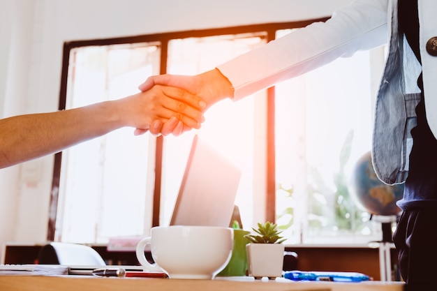 Deux femme d&#39;affaires ayant une poignée de main dans le bureau