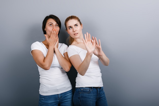 Deux femme levant les yeux avec émerveillement et geste repoussant.