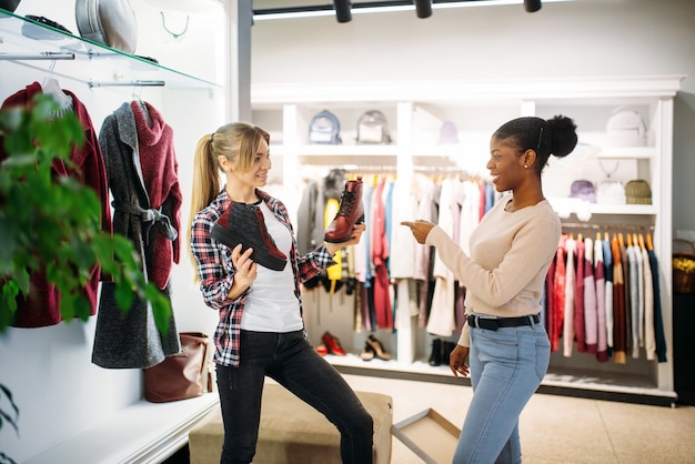 Deux femmes achètent des vêtements et des chaussures. Accro du shopping dans un magasin de vêtements, mode de vie de consommation, mode