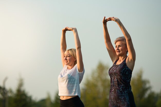 deux femmes adultes font du sport dans un parc d'été