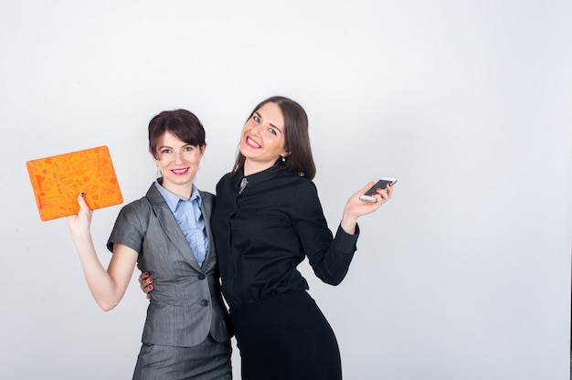 Deux femmes d'affaires debout et s'embrassent joyeusement en agitant les mains