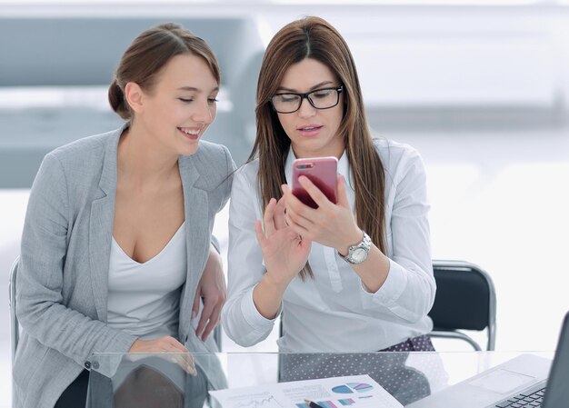 Deux femmes d'affaires regardant l'entreprise et la technologie de l'écran du smartphone
