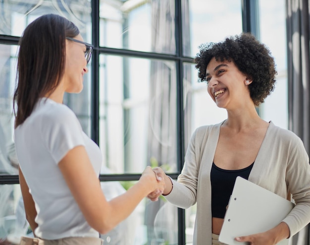 Deux femmes d'affaires se serrant la main dans un bureau moderne