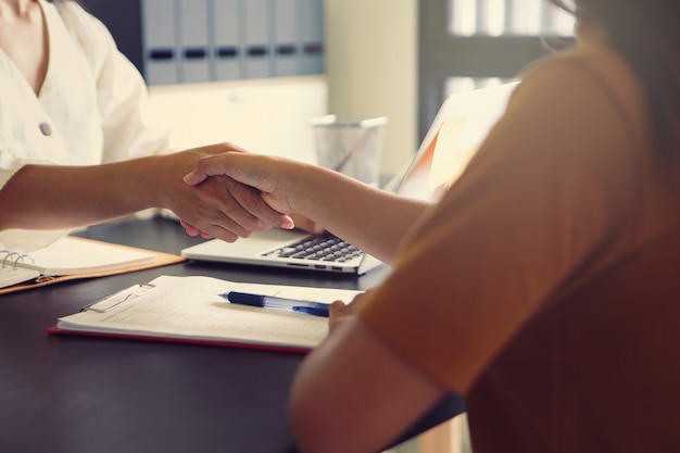 Deux femmes d'affaires se serrant la main pour féliciter le succès des négociations commerciales.