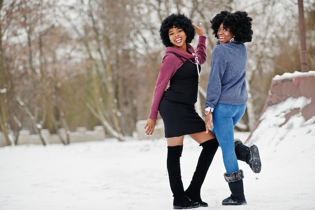 Deux femmes afro-américaines aux cheveux bouclés portent des chandails posés le jour de l'hiver