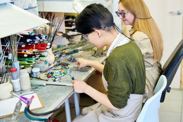 Deux femmes artistes travaillant dans l'atelier de verrerie