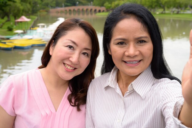 Photo deux femmes asiatiques matures ensemble se détendre au parc