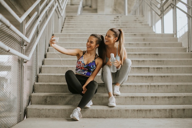 Deux femmes athlètes se reposant et prenant un selfie après un jogging