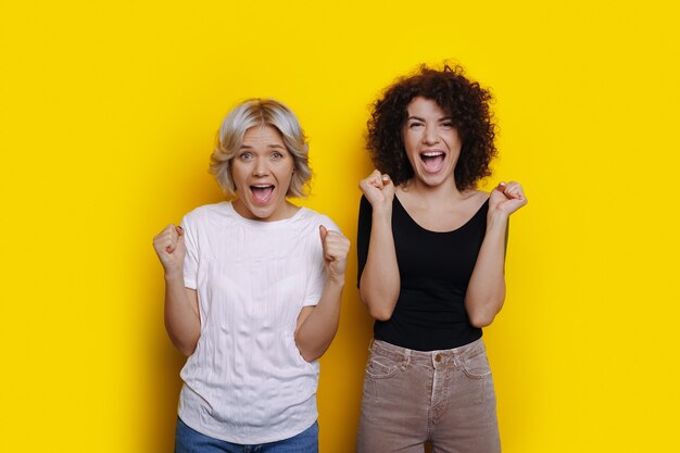 Deux femmes aux cheveux bouclés surpris crient