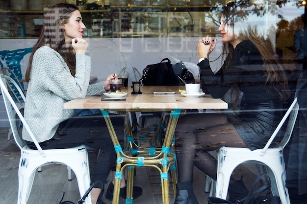 Photo deux femmes ayant le chat dans le café