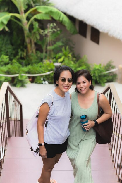 Deux femmes cheveux courts debout ensemble avec un sourire heureux regardant la caméra