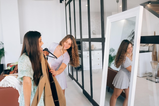 Deux femmes choisissent et essaient des vêtements à la maison