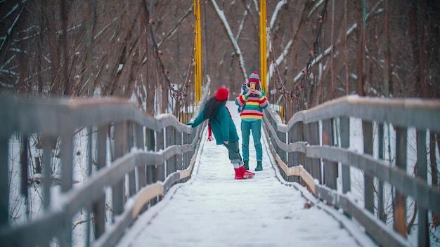 Deux femmes colorées prenant des photos sur un pont enneigé