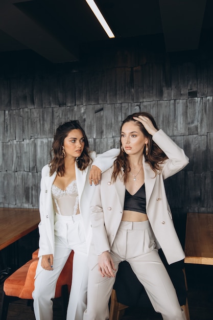 Deux femmes élégantes, sexy et glamour, portent des costumes blancs dans un restaurant.
