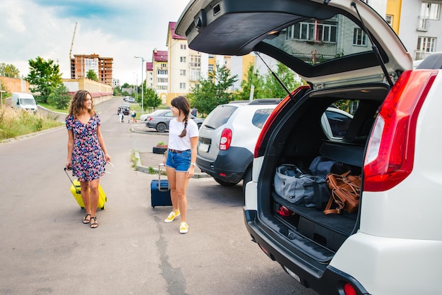 Deux femmes emballant leurs bagages dans le coffre de la voiture. voyage sur la route