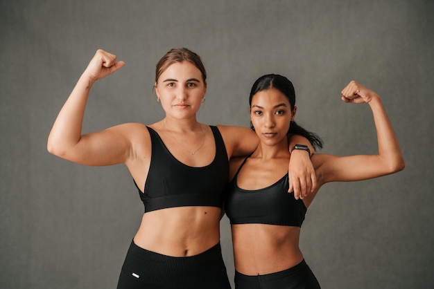 Deux femmes fléchissant les muscles de leurs bras et montrant leurs corps toniques