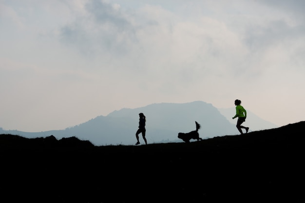 Deux femmes font la course dans les montagnes avec un chien