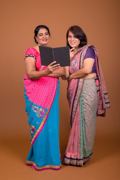 Deux femmes indiennes matures portant des vêtements traditionnels indiens Sari avec book