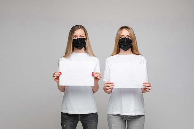 Deux femmes masquées avec des bannières. Arrêtez le concept de virus.