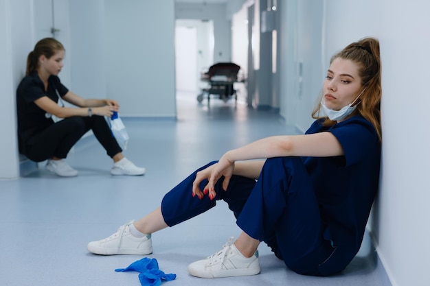 Deux femmes médecins après la chirurgie sont assises dans le couloir de la clinique Mise au point sélective sur une jeune femme au premier plan