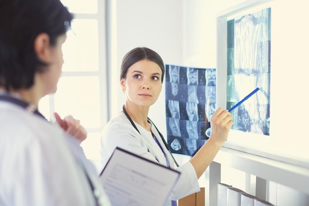 Deux femmes médecins pointant vers des radiographies dans un hôpital