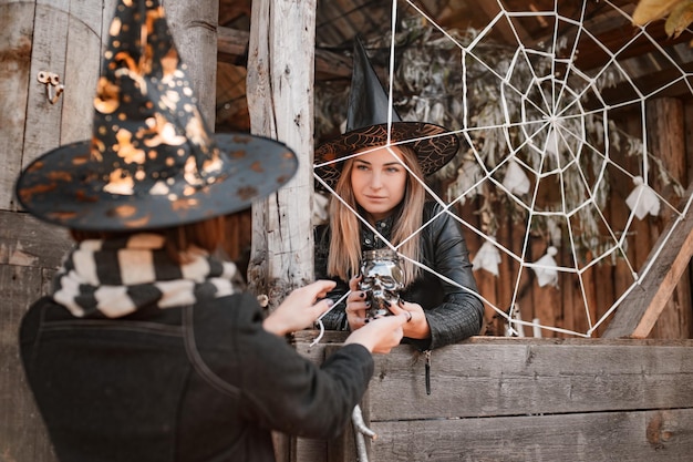 Deux femmes mystérieuses en costumes de mascarade de sorcière ou de sorcier à la fête d'halloween à la campagne