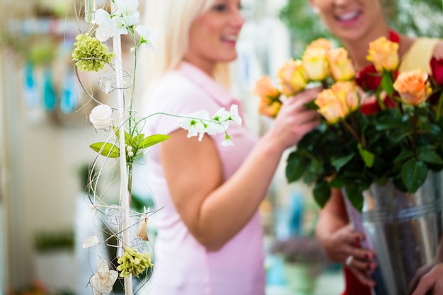 Deux femmes regardant un bouquet de roses dans un magasin de fleurs