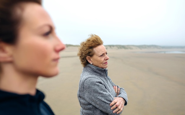 Deux femmes regardant la mer sur la plage en automne. Mise au point sélective sur la femme en arrière-plan