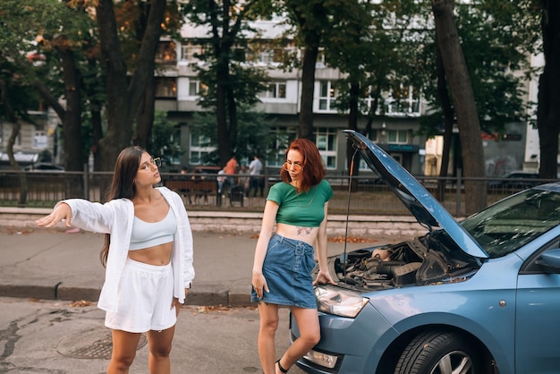 Deux femmes avec une route de voiture cassée cherchent de l'aide