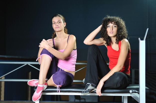 deux femmes s'entraînent et s'étirent dans un club de fitness