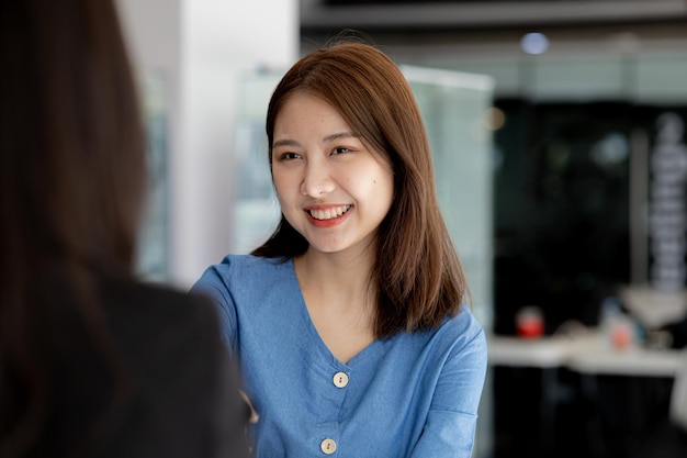 Deux femmes se serrent la main deux femmes d'affaires se serrent la main lorsqu'elles se rencontrent pour discuter de plans de remue-méninges et de marketing pour trouver des moyens plus rentables de se développer Idées de gestion d'entreprise pour une croissance rentable