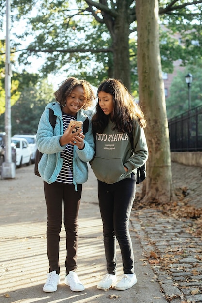 Photo deux femmes se tiennent sur un trottoir l'une d'elles porte un sweatshirt qui dit dan