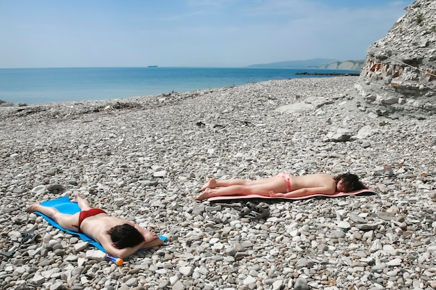 Deux femmes se trouvant sur la plage de pierre