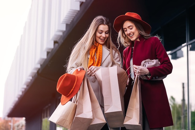 Deux femmes tenant des sacs à provisions vides avec tout en se tenant en arrière