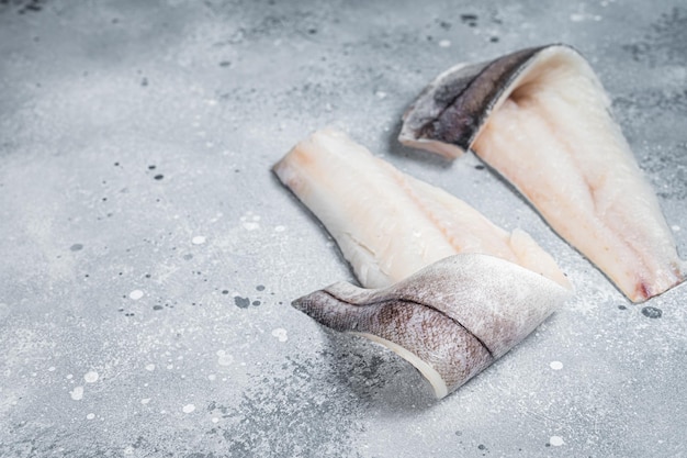 Deux filets de poisson d'aiglefin crus sur la table de la cuisine Fond gris Vue de dessus Espace de copie