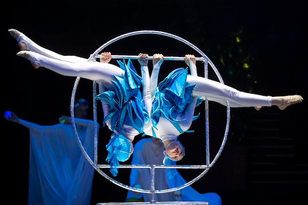 Photo deux filles acrobates montrent un numéro de cirque sur un fond sombre performance acrobatique
