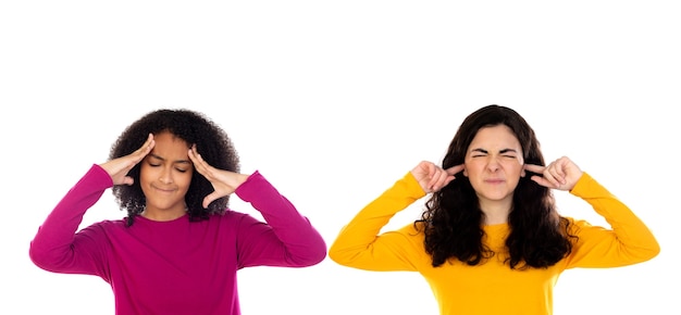 Deux filles adolescentes ennuyées couvrant ses oreilles isolé sur un blanc