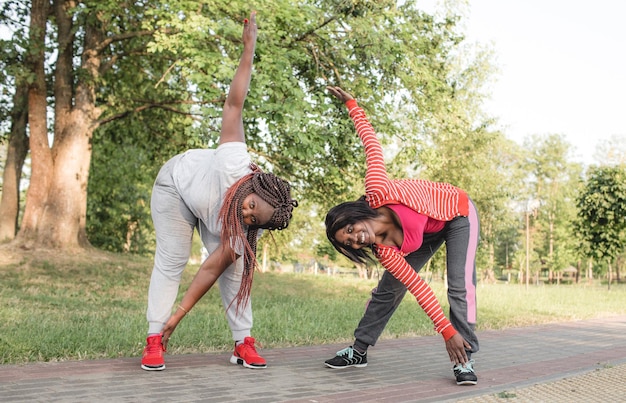 Deux filles afro-américaines font du sport et effectuent des virages en avant.