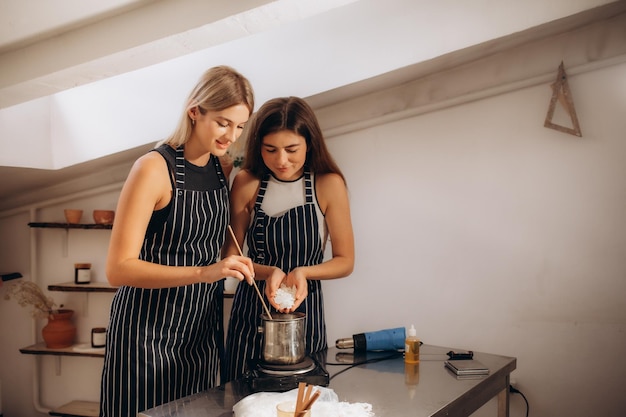 Deux filles d'un ami fabriquent des bougies dans l'atelier