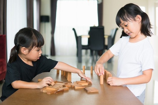 Deux filles asiatiques jouant des piles en bois à la maison