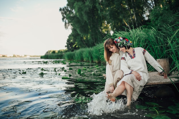 deux filles assis près de l&#39;eau et jouant