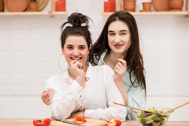 Deux filles brunes étreignant et regardant la caméra