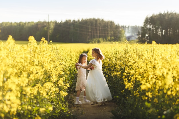 deux filles dans un champ de colza en été