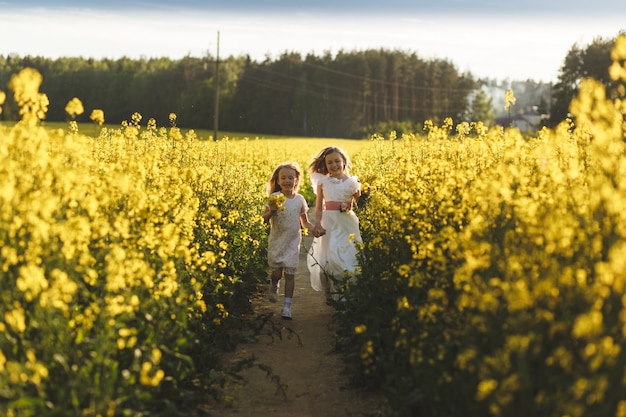 deux filles dans un champ de colza en été