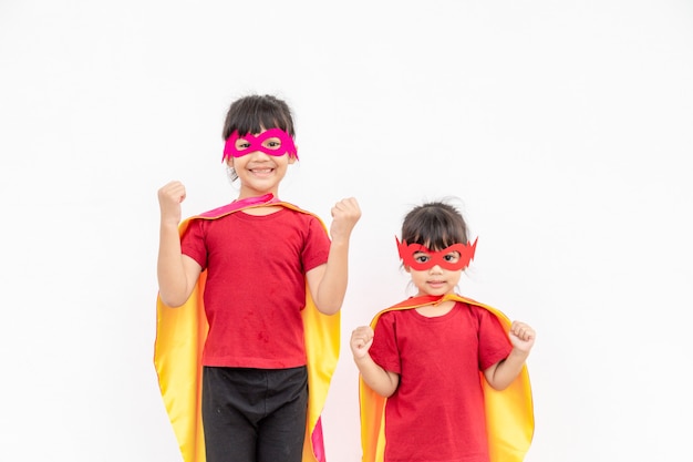 Deux filles dans un costume de super-héros sur fond blanc