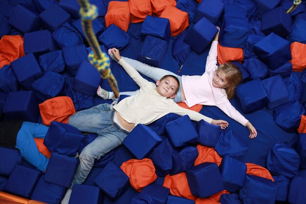 Photo deux filles dans la piscine avec des cubes mous colorés. centre de divertissement pour enfants. enfance heureuse