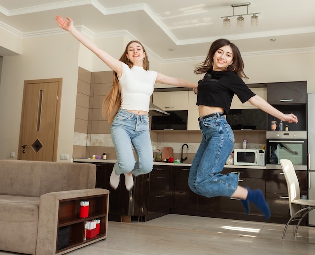 Deux filles drôles sautant dans le salon